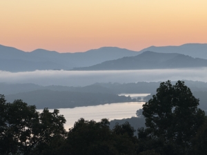 Serene peach sunrise over Lake Chatuge and the Blue Ride Mountains, the home of HSP Retreats.